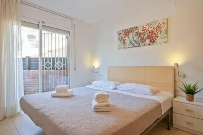 a bedroom with a bed with two towels on it at Apartamentos Velor in Castelldefels