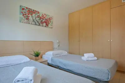 a bedroom with two beds and a painting on the wall at Apartamentos Velor in Castelldefels