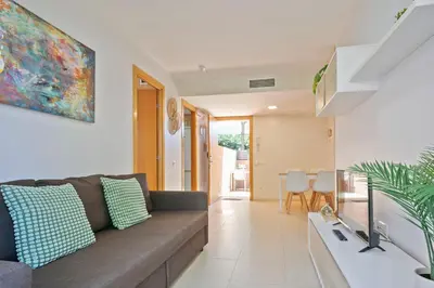 a living room with a couch and a tv at Apartamentos Velor in Castelldefels