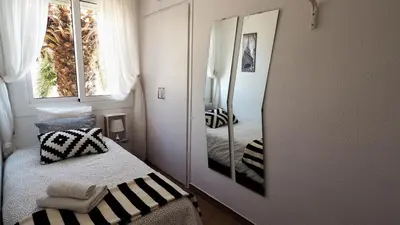 a small bedroom with a mirror and a bed at Cristina Port & Beach - Apartment in Masnou