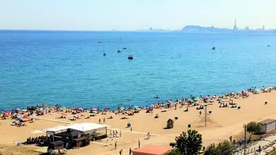 a group of people on a beach in the water at Cristina Port & Beach - Apartment in Masnou