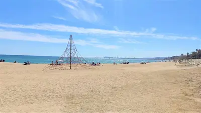 a group of people sitting on a beach at Cristina Port & Beach - Apartment in Masnou
