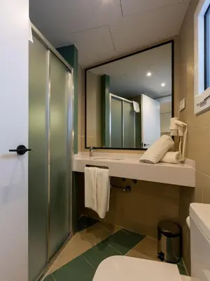 a bathroom with a shower and a sink and a mirror at Apartamentos Sunway Atlanta in Sitges