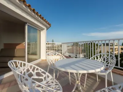 a patio with a table and chairs on a balcony at Apartamentos Sunway Atlanta in Sitges