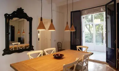 a dining room with a wooden table and a mirror at Can Calixto in Aiguafreda