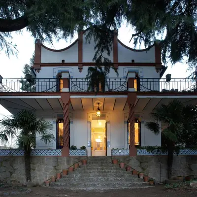 a large white house with stairs leading to the front door at Can Calixto in Aiguafreda