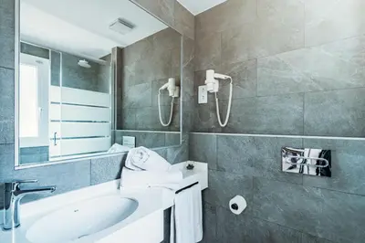 a bathroom with a sink and a mirror at Apartamentos Sunway Apollo in Sitges