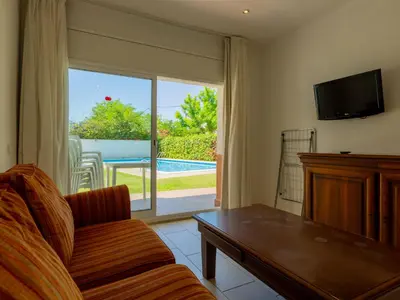 a living room with a couch and a sliding glass door at Apartamentos Sunway San Jorge in Sitges