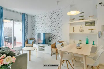 a living room with a table and a tv at Alcam Rogent in Barcelona