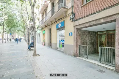 a man sitting on a bench in front of a building at Alcam Rogent in Barcelona