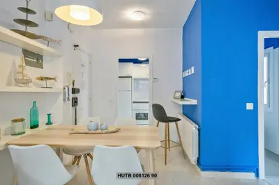 a dining room with a blue wall and a table and chairs at Alcam Rogent in Barcelona