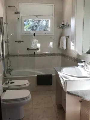 a bathroom with a toilet and a tub and a sink at Villa Rosa Sitges in Can Trabal