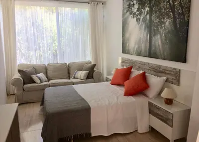 a living room with a bed and a couch at Villa Rosa Sitges in Can Trabal