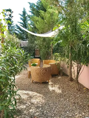 a patio with chairs and a table and trees at Villa Rosa Sitges in Can Trabal