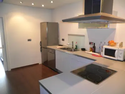 a kitchen with a stainless steel refrigerator and a microwave at Bacrou apartment, design loft near the sea in Barcelona