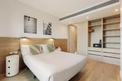 a bedroom with a large white bed and shelves at Ola Living Boqueria in Barcelona