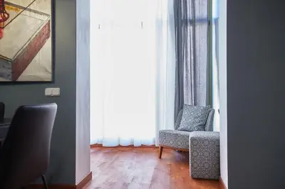 a living room with a chair and a window at Alcam Plaza Cataluña in Barcelona