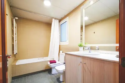 a bathroom with a toilet and a sink and a bath tub at Alcam Plaza Cataluña in Barcelona