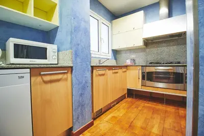 a kitchen with wooden cabinets and a microwave at Alcam Plaza Cataluña in Barcelona