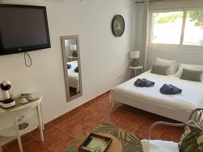 a bedroom with a bed and a tv and a mirror at Casa Mallarenga Rooms in Olivella