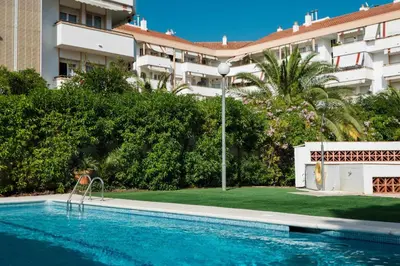 a swimming pool in front of a building at Sitges Colonial - al lado de la playa in Sitges