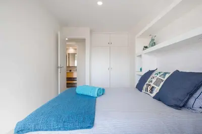 a bedroom with a bed with a blue blanket at Sitges Colonial - al lado de la playa in Sitges