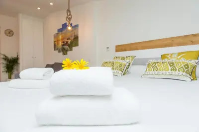 a white bed with towels on top of it at Rambla de Marisol Apartments in Castelldefels