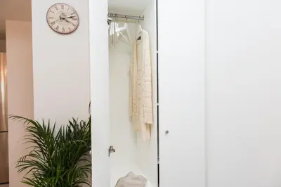 a clock hanging on a wall next to a closet at Rambla de Marisol Apartments in Castelldefels