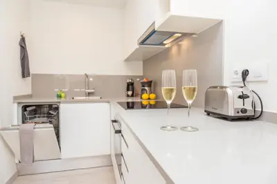 a kitchen with two glasses of wine on the counter at Rambla de Marisol Apartments in Castelldefels