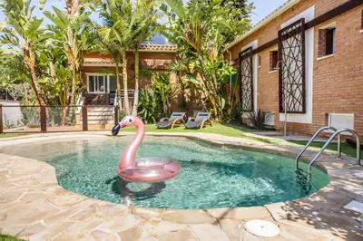 a swimming pool with a pink flamingo in the water at Rambla de Marisol Apartments in Castelldefels