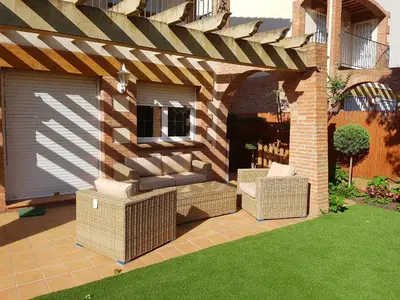 a pergola with wicker chairs on a patio at Vil·la La Garriga Termal Congost in La Garriga