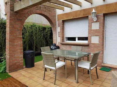 an outdoor patio with a glass table and chairs at Vil·la La Garriga Termal Congost in La Garriga