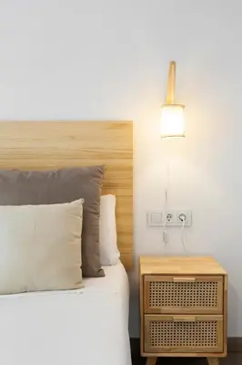 a bedroom with a bed with a wooden headboard and a lamp at KeyFamily Cozy Home in Barcelona