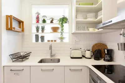 a kitchen with white cabinets and a sink at KeyFamily Cozy Home in Barcelona