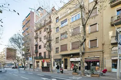 a building on a city street with trees and buildings at KeyFamily Cozy Home in Barcelona