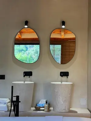 two mirrors above two sinks in a bathroom at Boutique hotel Urbisol in Calders