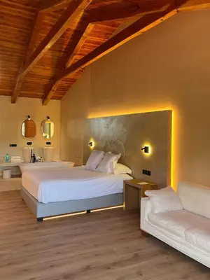 a bedroom with a large bed and a couch at Boutique hotel Urbisol in Calders