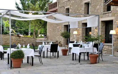 a restaurant with white tables and chairs and a white canopy at Boutique hotel Urbisol in Calders