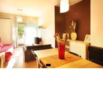 a living room with a table with a vase on it at Good-Apartments Barcelona in Barcelona
