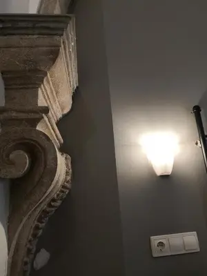 a light on a wall next to a column at La Terrassa in Barcelona