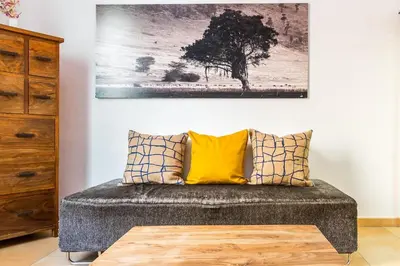 a living room with a couch and a painting on the wall at Fridays Flats Dreamy Duplex - Stylish Beach Loft in Barcelona