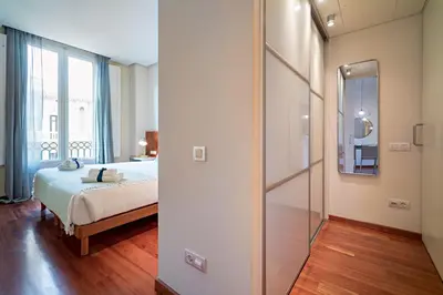 a bedroom with a bed and a sliding glass door at Habitat Apartments Paseo de Gracia Suite in Barcelona