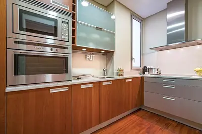 a kitchen with wooden cabinets and stainless steel appliances at Habitat Apartments Paseo de Gracia Suite in Barcelona