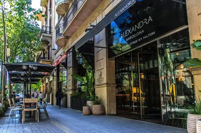 a store front of a street with tables and an umbrella at Habitat Apartments Paseo de Gracia Suite in Barcelona