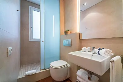 a bathroom with a sink and a toilet and a mirror at Habitat Apartments Paseo de Gracia Suite in Barcelona