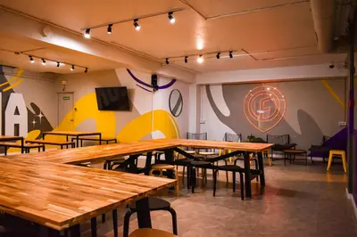 a restaurant with wooden tables and chairs and a target on the wall at Onefam Les Corts in Barcelona
