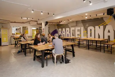 a group of people sitting at tables in a restaurant at Onefam Les Corts in Barcelona