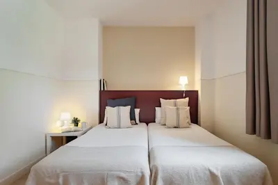 a bedroom with a large bed with white sheets and pillows at Apartments Sata Olimpic Village Area in Barcelona