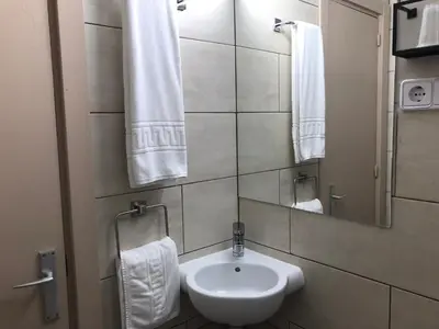 a bathroom with a sink and a mirror and towels at Hostal Radio Barcelona in Barcelona