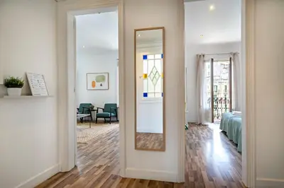 a hallway with a mirror and a room with a bed at Habitat Apartments Eixample Balconies. in Barcelona